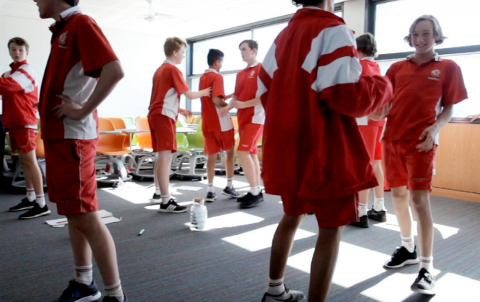 Students standing in a classroom talking to each other